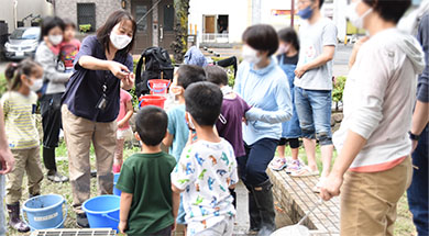 写真:田んぼで見つけた生き物について解説しているところ